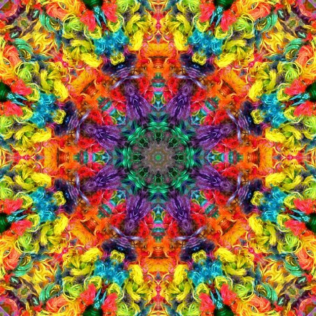 Colorful symmetrical mandala with intricate kaleidoscope patterns in red, yellow, blue, green, and purple hues