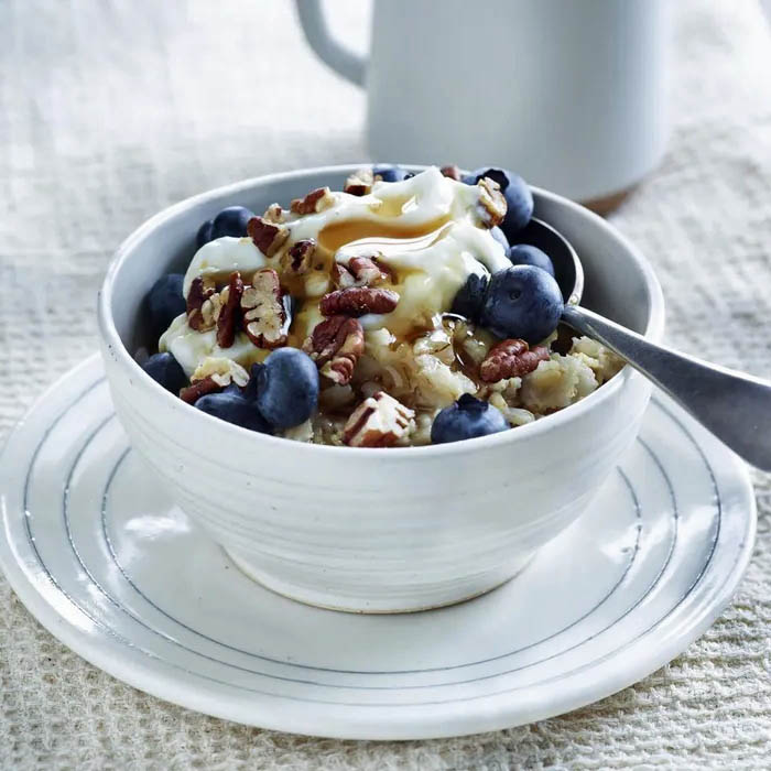 Bowl of oatmeal topped with blueberries and pecans