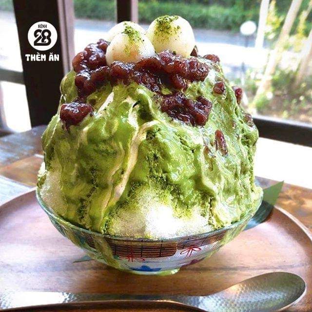 Bowl of green matcha shaved ice topped with red beans and ice cream scoops