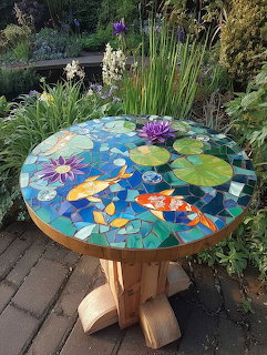Round mosaic table with koi fish and water lilies design in garden
