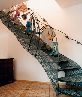 Elegant spiral staircase with decorative iron railings and blue copper details in modern interior