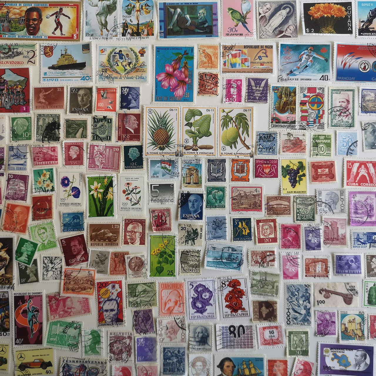 Collage of many colorful vintage postage stamps arranged closely together on a white background