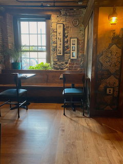 Cozy cafe interior with wooden chairs, brick walls, and a large window