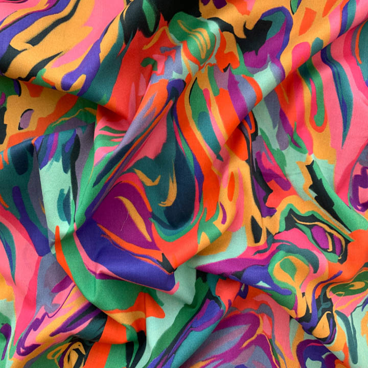 Close-up of colorful abstract patterned fabric draped in soft folds