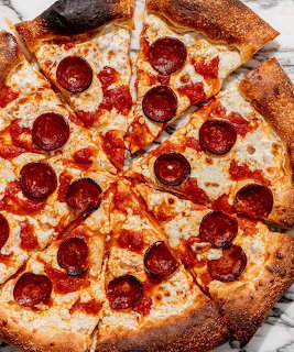 Pepperoni pizza with melted cheese and crispy crust on marble counter
