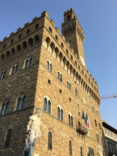 Palazzo Vecchio medieval stone building with tower and classical statue, Florence, Italy