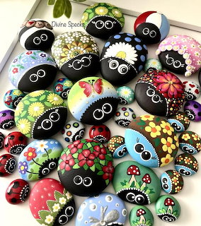Colorful hand-painted rocks with floral designs, ladybugs, and cartoon bug faces with googly eyes