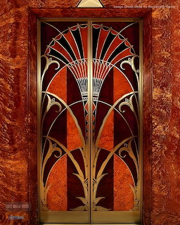 Ornate Art Deco elevator door with symmetrical fan pattern in orange and gold against dark background