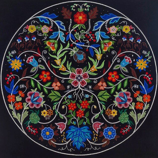 Circular mandala painting with colorful flowers and vines symmetrically arranged on black background