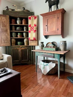 Vintage country home interior with wooden furniture, corner cupboard, antique wall cabinet, and rustic decor