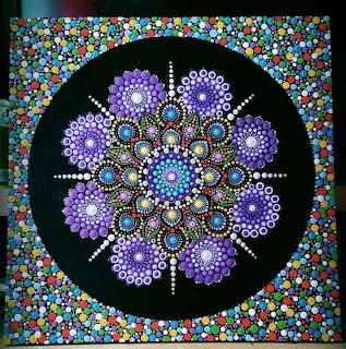 Circular dot mandala with purple floral pattern and multicolored border on black background