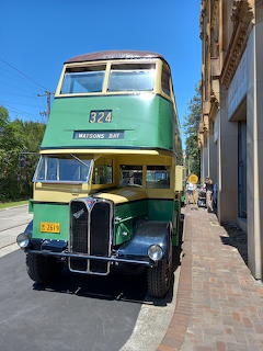Green vintage double-decker bus 822 parked on sunny Sydney street