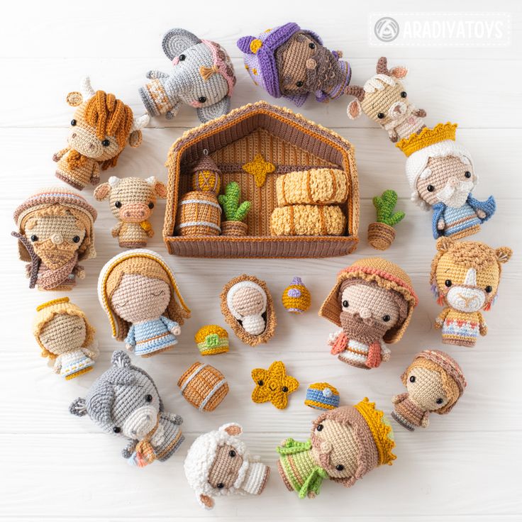 Crocheted nativity scene dolls arranged in circle around wooden stable with hay