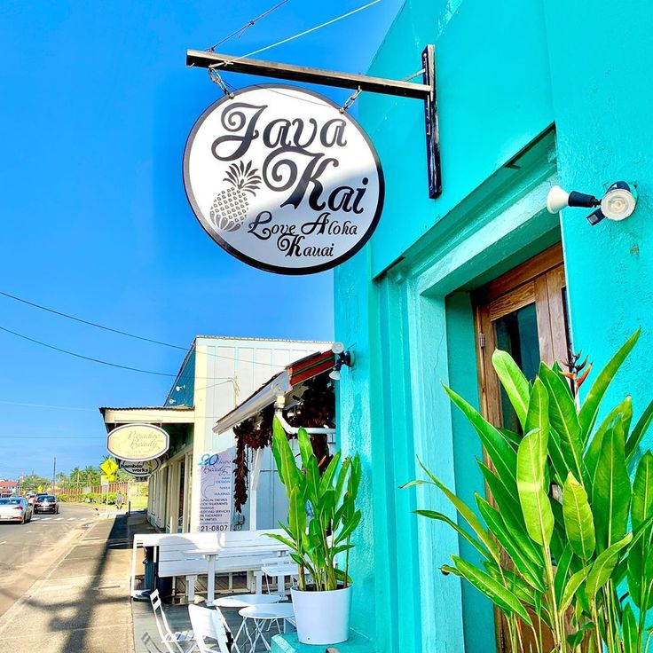 Java Kai Love Aloha sign on a turquoise storefront beside a sunny street