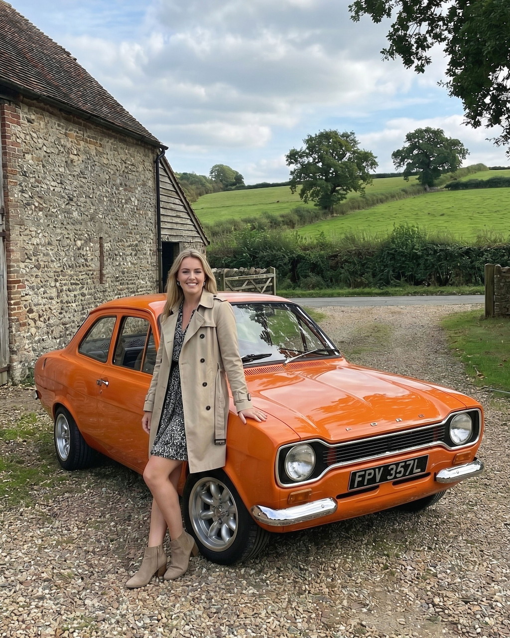 Woman posing with vintage orange Ford Escort Mk1 in rural cottage driveway