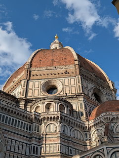 Brunelleschi's dome of Florence Cathedral viewed from below with blue sky and clouds