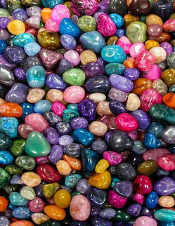 Colorful assortment of polished gemstones and decorative rocks in many bright colors