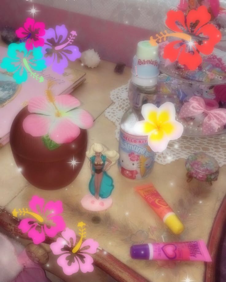 Flat lay of a tropical-themed desk with coconut cup, hibiscus flower stickers, figurines, and beauty products