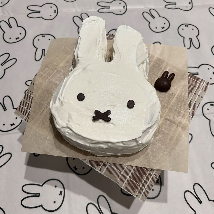 White Miffy bunny-shaped cake with simple black facial features on a table
