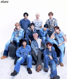 Ten members of K-pop group xikers posing together wearing denim outfits in a studio setting