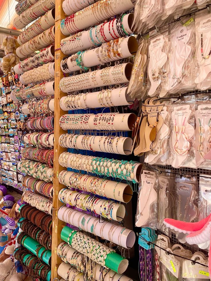Shelves packed with rolled bracelet cards and accessories in a beach souvenir shop