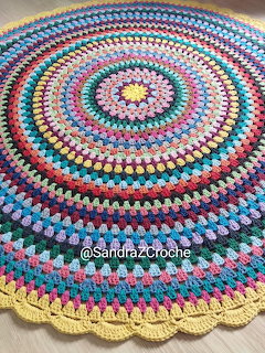 Colorful round crochet mandala rug with concentric circles of multicolored yarn patterns