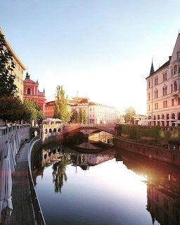 Ljubljanica River with Triple Bridge and colorful historic buildings in Ljubljana, Slovenia at golden hour