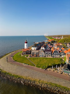 Aerial view of Urk village in the Netherlands with lighthouse, traditional houses, and sea