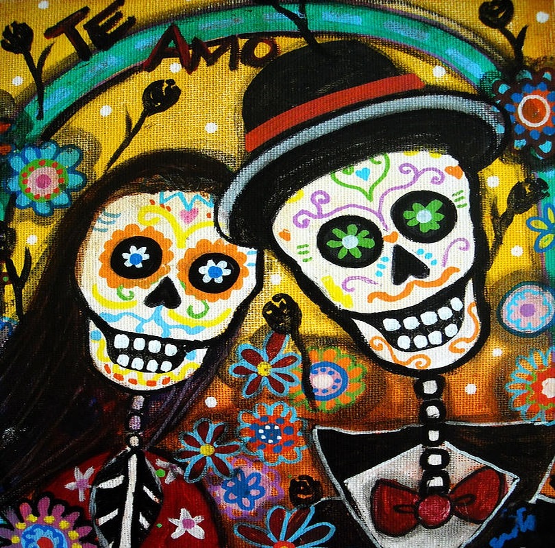 Two decorated Day of the Dead skulls dressed as bride and groom with colorful flowers and patterns