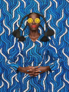 Stylized portrait of a woman in blue patterned clothing against a matching wavy blue background