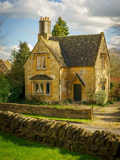 Traditional stone cottage with tower and arched windows in English countryside