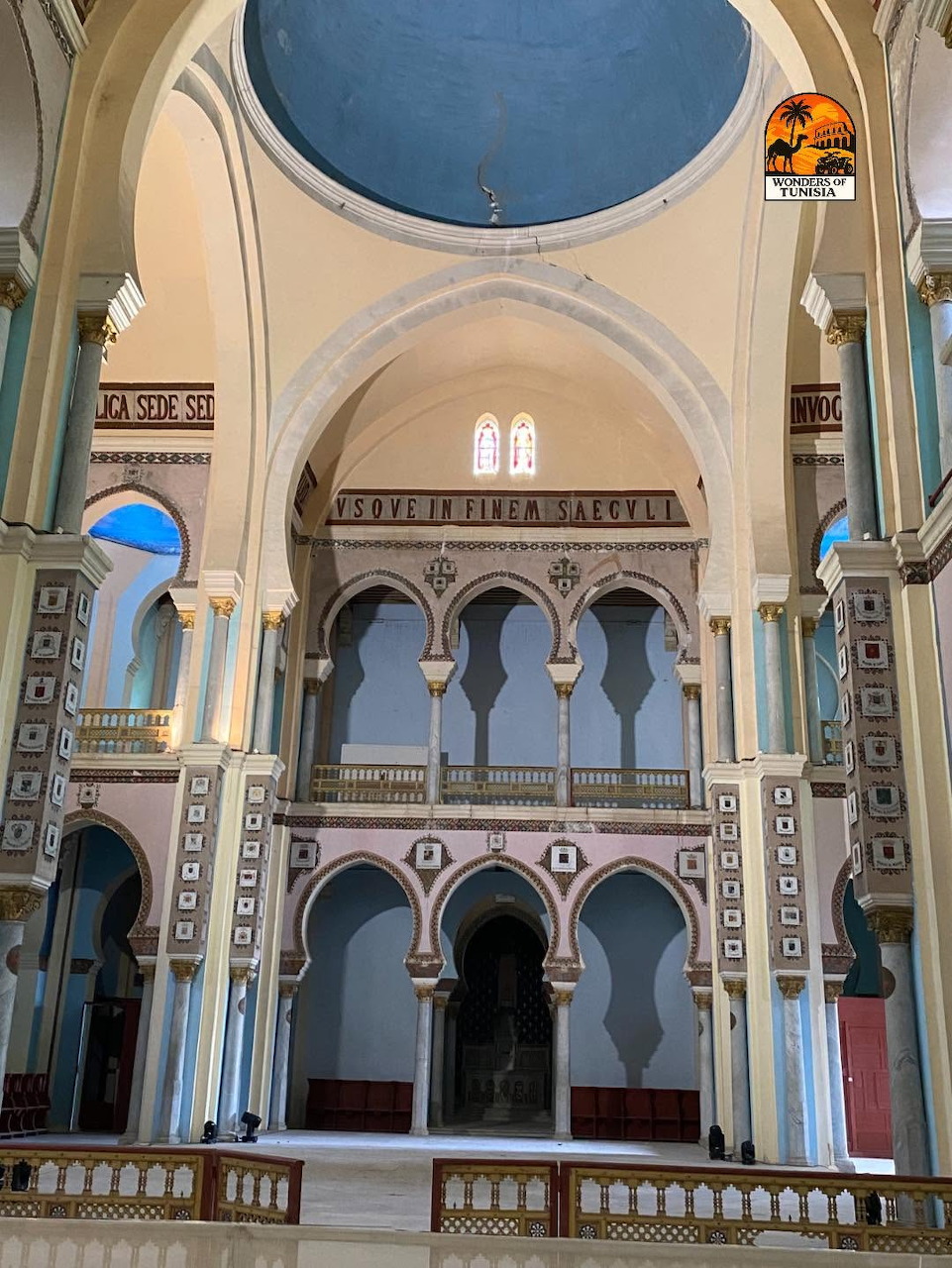 Interior of cathedral with blue dome, ornate arches, and decorative balconies