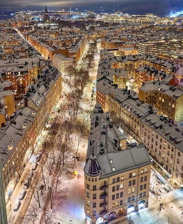 Aerial view of Stockholm city center at dusk with snow-covered streets and illuminated buildings