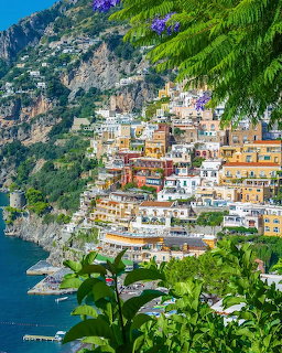 Colorful hillside buildings of the Amalfi Coast cascading down rocky cliffs to the sea