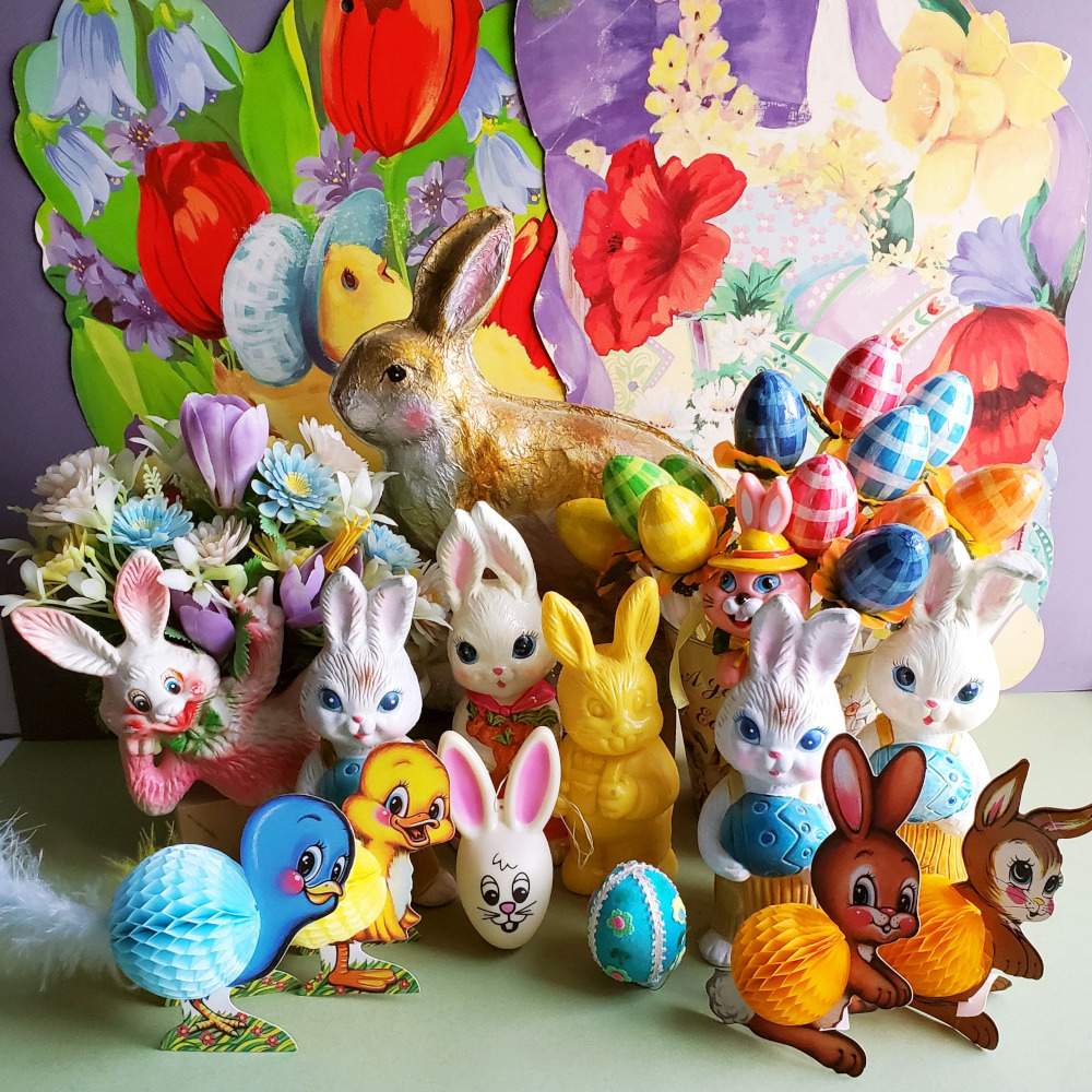 Collection of Easter bunny figurines with decorated eggs and spring flowers