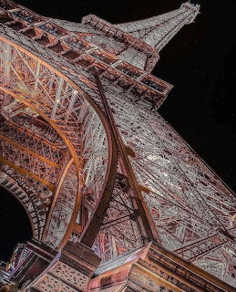 Upward view of illuminated Eiffel Tower iron structure at night