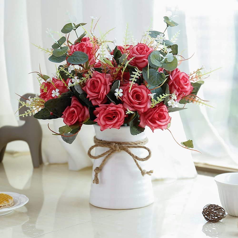 Pink rose bouquet in white vase tied with twine on sunny windowsill