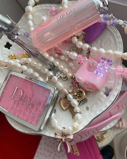 Heart-shaped tray with pearl jewelry, pink Dior blush, lip gloss, crystal beads and bow charms