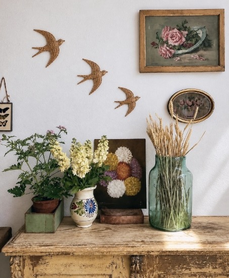 Rustic interior with flower arrangements on a wooden table and framed wall decor