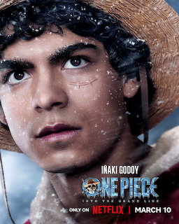 Young man with curly hair and straw hat looking upward with determined expression, water droplets on face