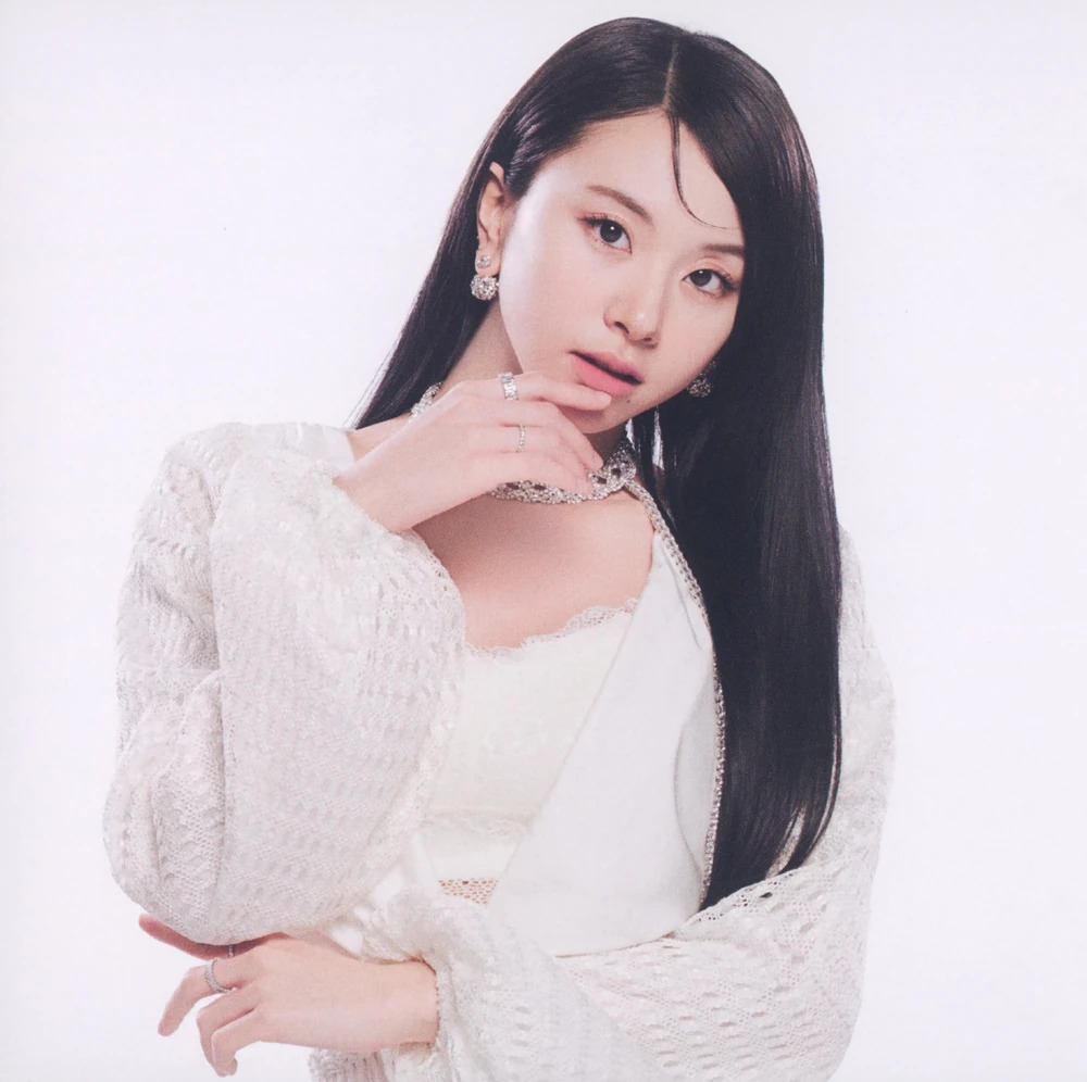 Studio portrait of a young woman with long black hair in a white outfit and silver jewelry