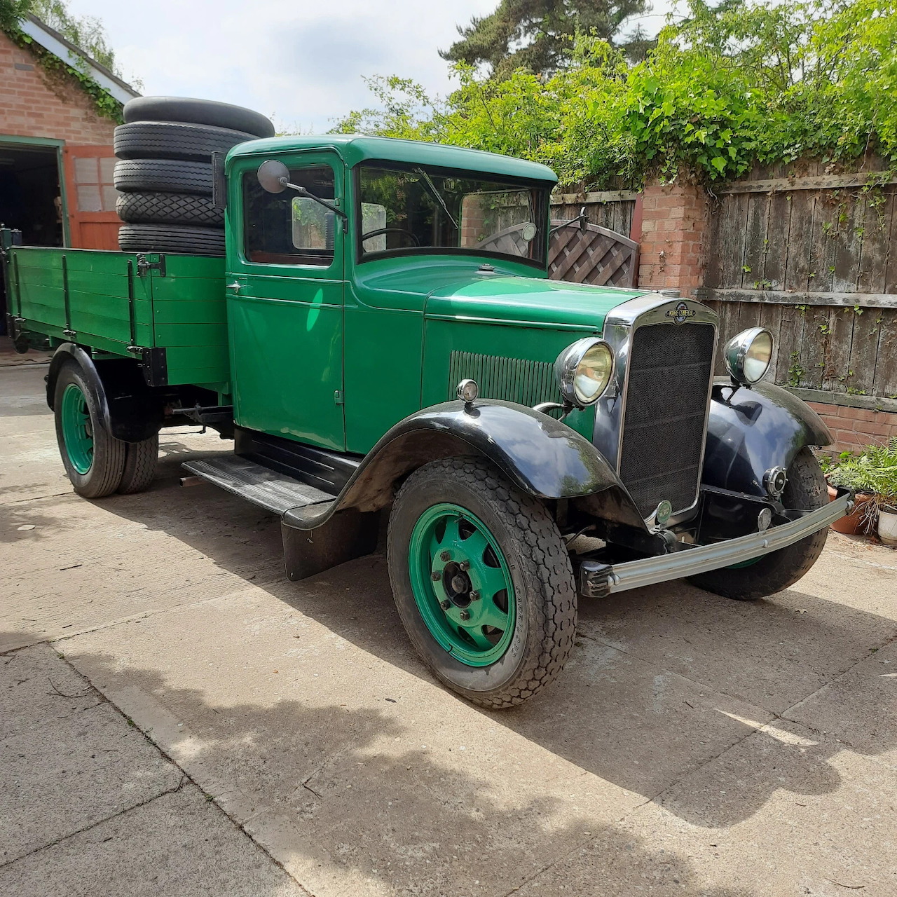 Green 1934 Morris C Type vintage truck parked on residential driveway