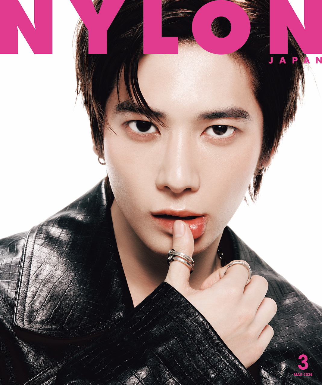 Young male K-pop artist on Nylon Japan magazine cover, black leather jacket, finger to lips pose