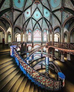 Ornate courthouse interior with spiral staircase and Gothic arched ceiling with stained glass