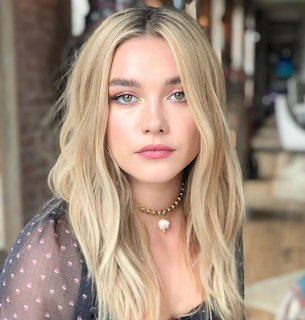 Portrait of Florence Pugh with blonde hair and natural makeup wearing a polka dot top