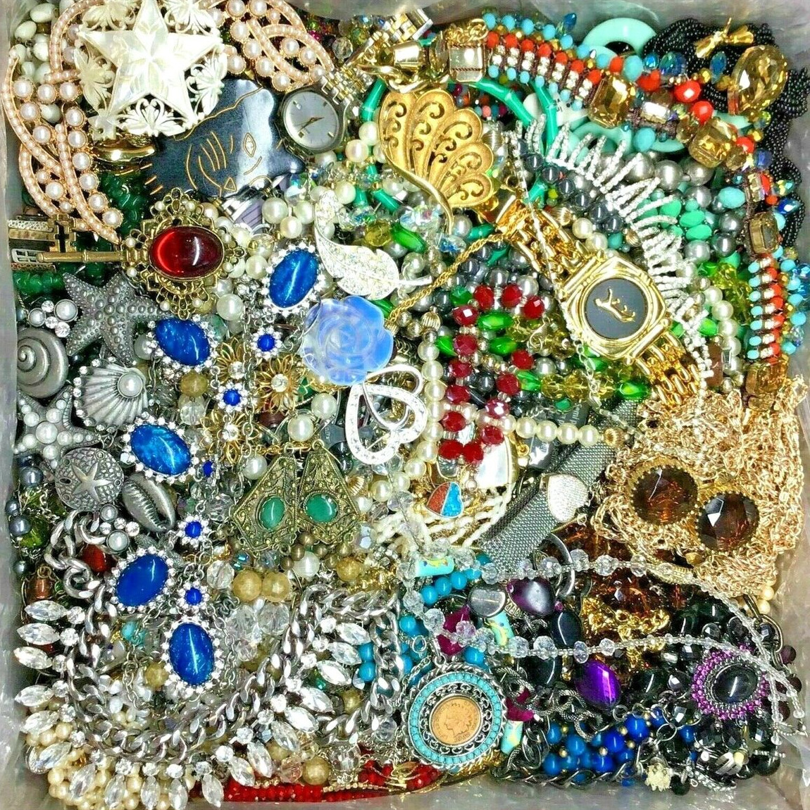 Assorted vintage costume jewelry with colorful beads, pearls, brooches, and rhinestone accessories arranged together
