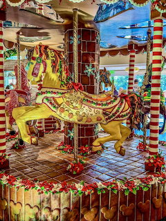 Large gingerbread carousel decorated with candy canes, colorful icing, and festive ornaments