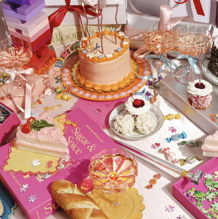 Pastel party table with a decorated cake, desserts, gifts, ribbons, and candy