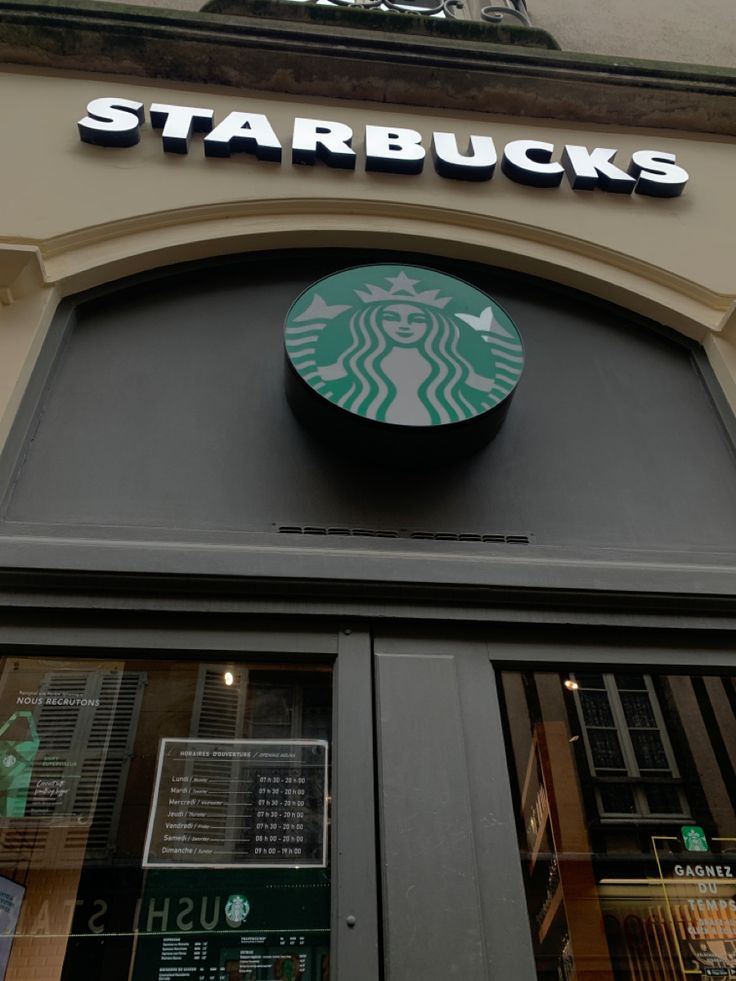 Starbucks storefront with green siren logo and white lettering above a dark entrance