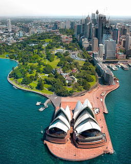 Aerial photo of Sydney Opera House with harbour, botanic gardens, and city skyline in background
